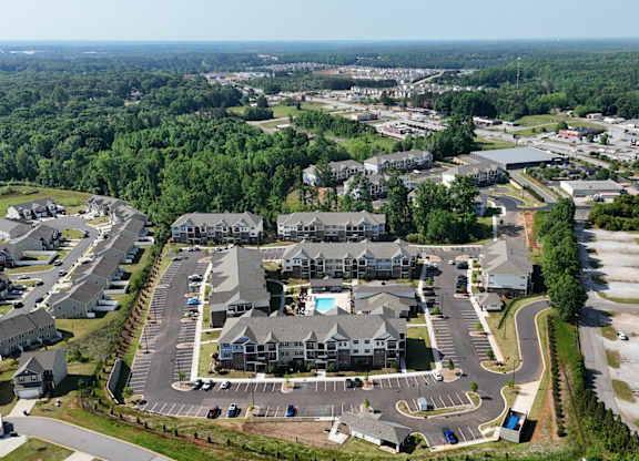 A bird's eye view of a residential area with houses and a parking lot.