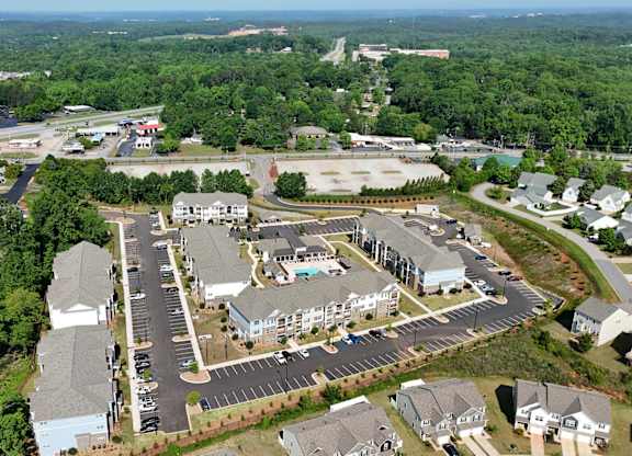 A bird's eye view of a residential area with houses and a parking lot.