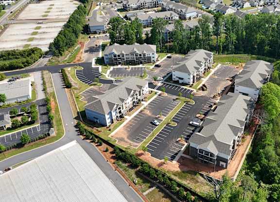 A bird's eye view of a residential area with houses and a parking lot.