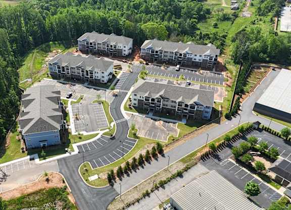 An aerial view of a residential complex with multiple buildings and parking lots.