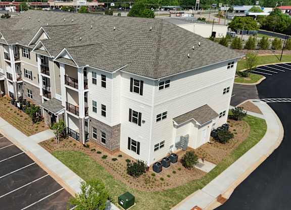 A large white building with a parking lot in front.