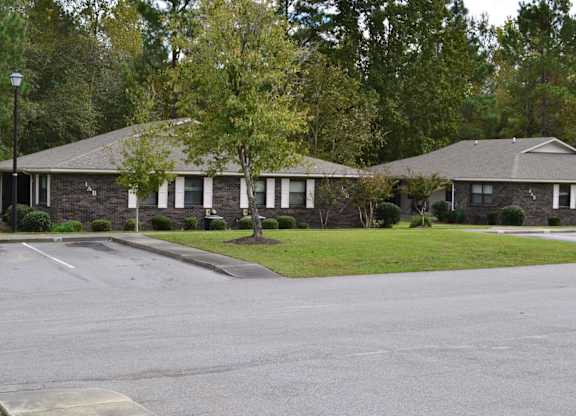 A street view of a residential area with houses and trees.