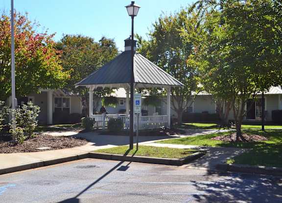 A gazebo is in the middle of a grassy area.