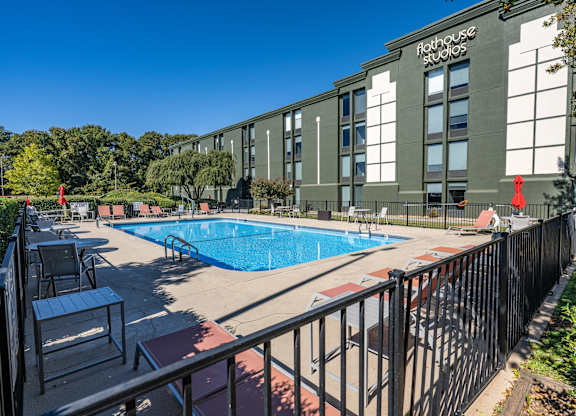 A pool area in front of a building with the words Flat House Studios on it.