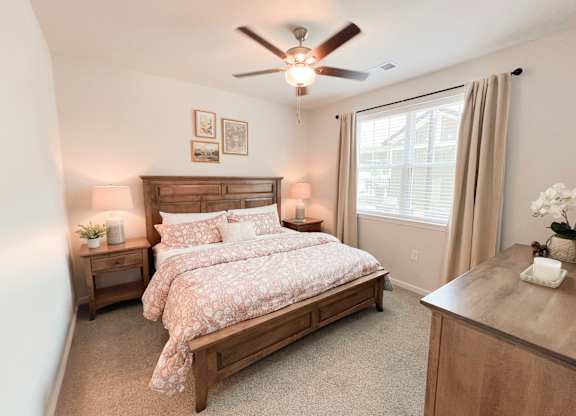 Pet-Friendly Luxury Apartments In Boiling Springs, SC - Grande At Geyser Falls - Carpeted Bedroom Featuring A Large Bed And A Ceiling Fan