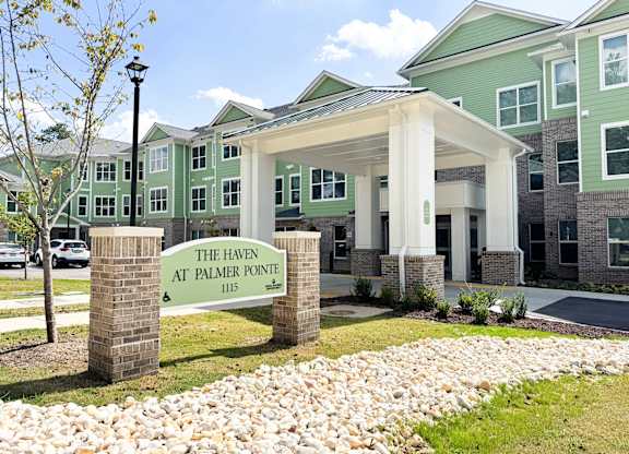 The Haven at Palmer Pointe Senior Apartments Entrance with carport and a sign that reads "The Haven at Palmer Pointe"