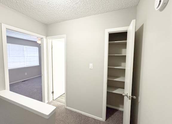 Reserve at Hillcrest upstairs with closet with shelves, a carpet, a bathroom and two bedrooms.
