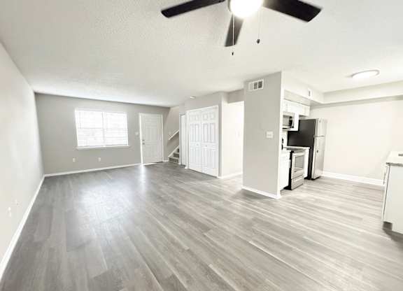 Reserve at Hillcrest living room with LVT flooring, washer and dryer hookups, bathroom, kitchen, closet and carpeted stairs.