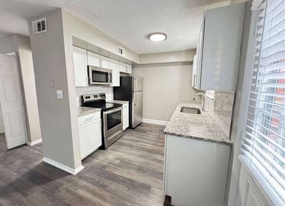 Reserve at Hillcrest Townhomes kitchen with granite countertops, white cabinetry and stainless steel appliances