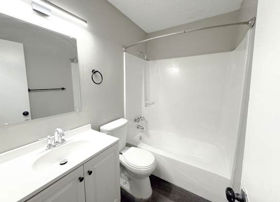 Reserve at Hillcrest Townhomes bathroom with bath/shower, toilet, and white sink with stainless steel faucet