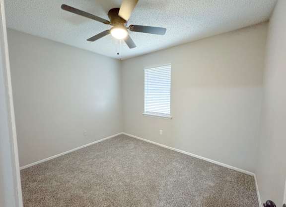 Reserve at Hillcrest Townhomes bedroom with carpet, a window with blinds and a ceiling fan with light