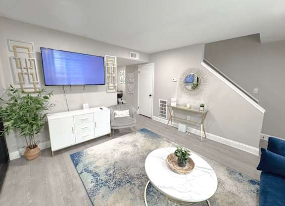 Reserve at Hillcrest model unit staged living room with TV, LVT Flooring, and furniture.