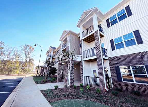 an apartment building with a sidewalk in front of it