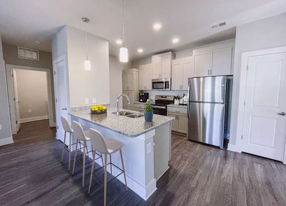 A kitchen with a white island and stainless steel appliances.