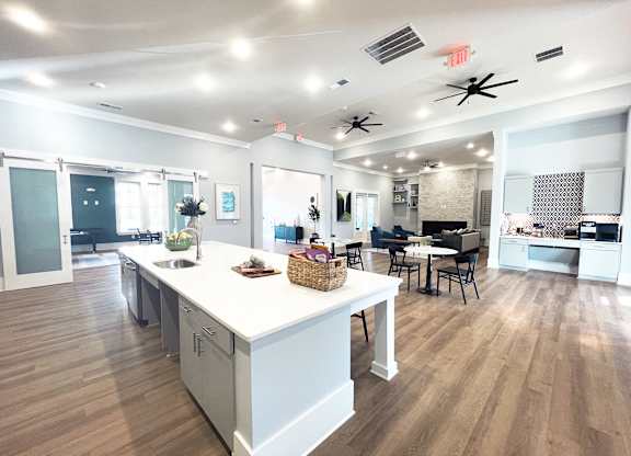 an open kitchen and living room with a large island and a dining room table