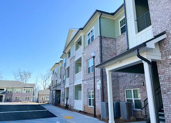 A row of townhouses with a clear blue sky above.