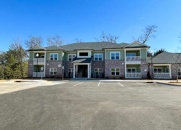 A large building with a parking lot in front.