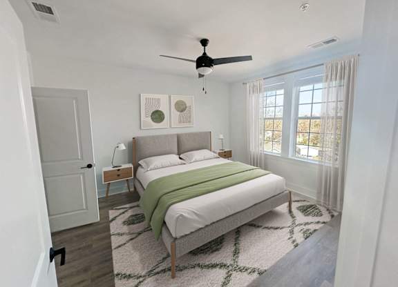 Gordon Street Lofts Bedroom with bed, rug, dresser and floor-to-ceiling curtains.