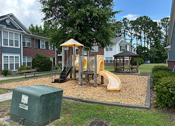 a playground in a park in front of some apartments