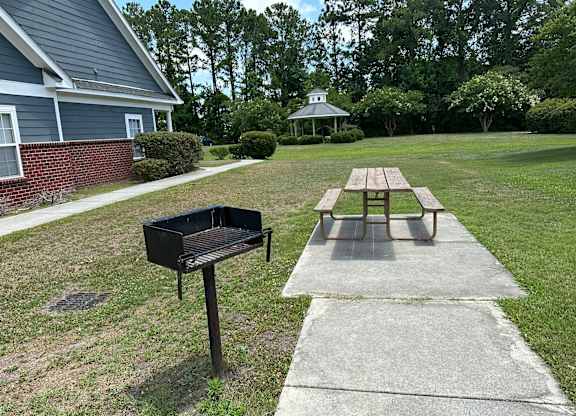 a picnic table and a grill in a yard