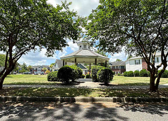 a gazebo in the middle of a park with trees