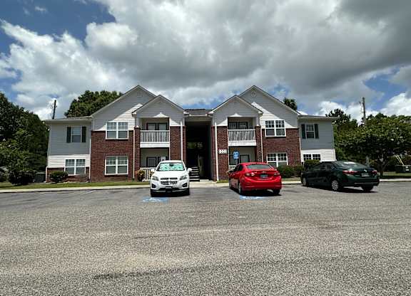 a large apartment building with cars parked in front of it