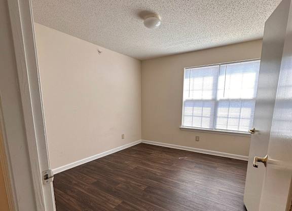A room with wooden floors and a window.