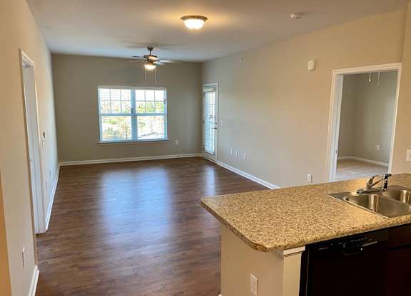 an empty kitchen and living room with a large window