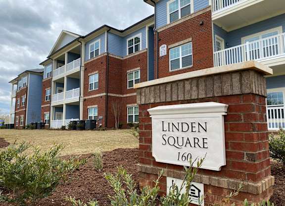 Exterior of Linden Square Apartments, with a sign in front of the building.