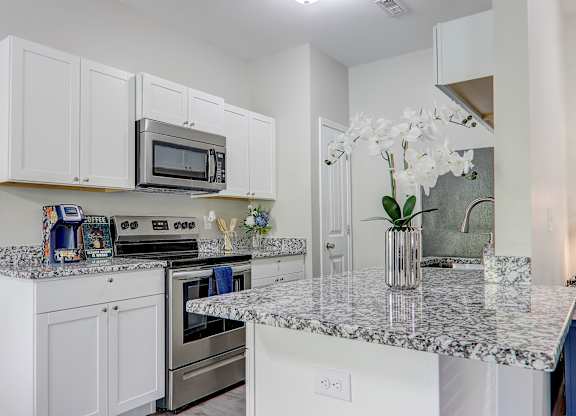 a kitchen with granite counter tops and stainless steel appliances