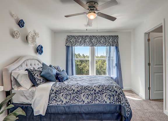 a bedroom with a large bed and a ceiling fan