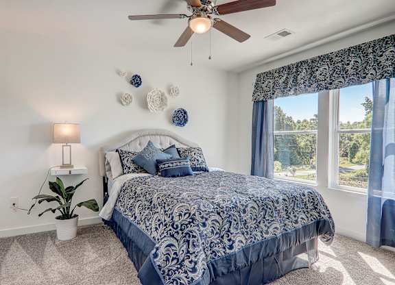 a bedroom with a bed and a ceiling fan