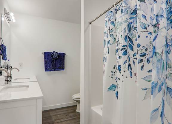 a bathroom with a shower curtain and a sink and a toilet