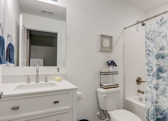 a white bathroom with a shower and a sink and a toilet