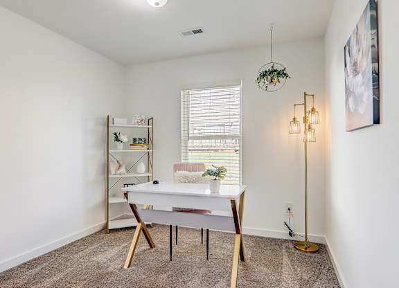 a home office with a white desk and a window