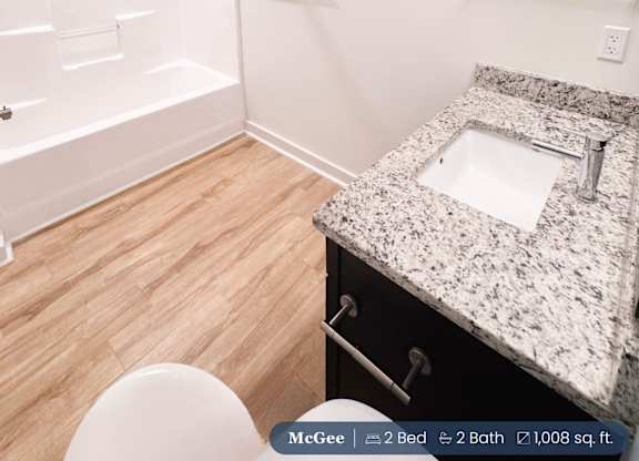 A small bathroom with a toilet, sink, and shower.