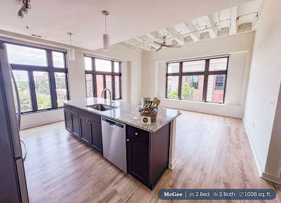A kitchen with a black countertop and a refrigerator.