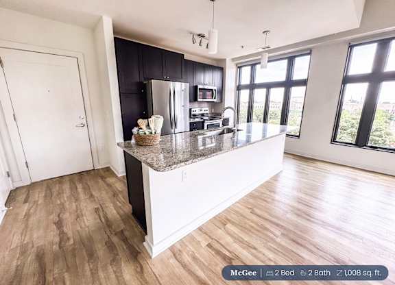 A kitchen with a large island and a view of the city.