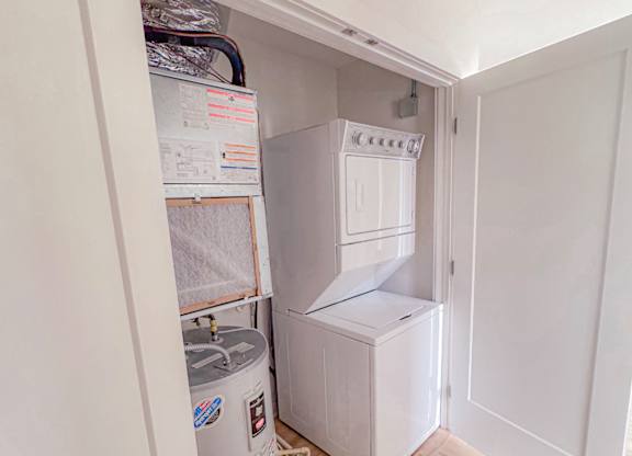 A small kitchen with a fridge, a freezer, and a water filter system.