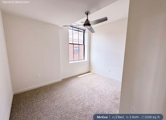 A second bedroom with a fan and a window.