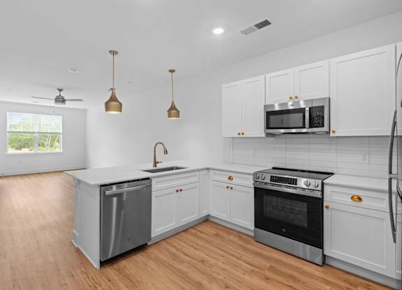 A kitchen with white cabinets and a black stove top oven.