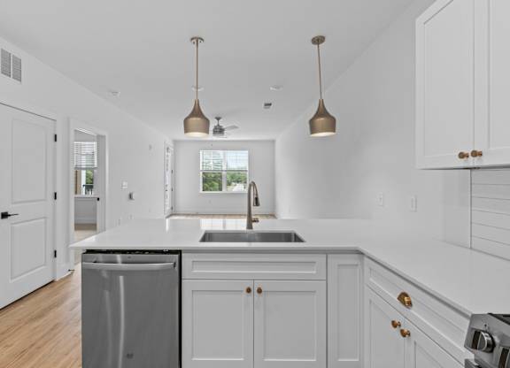 A kitchen with white cabinets and a black countertop.