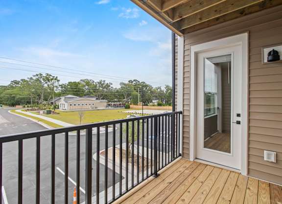 A balcony with a black railing and a white door.