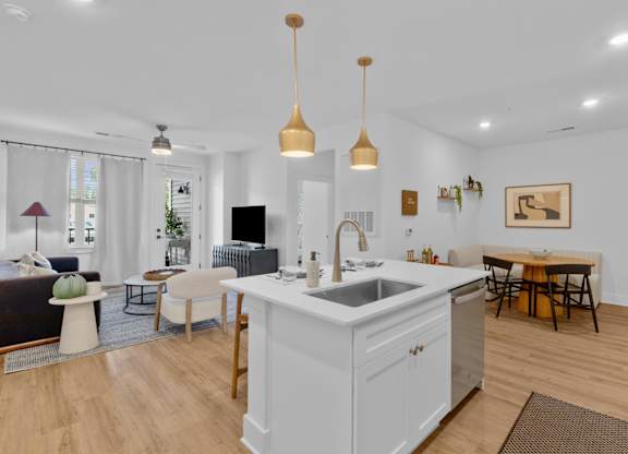 A kitchen with a white island and wooden floors.