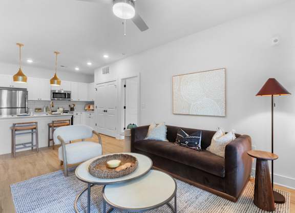 A living room with a brown couch and a grey table.