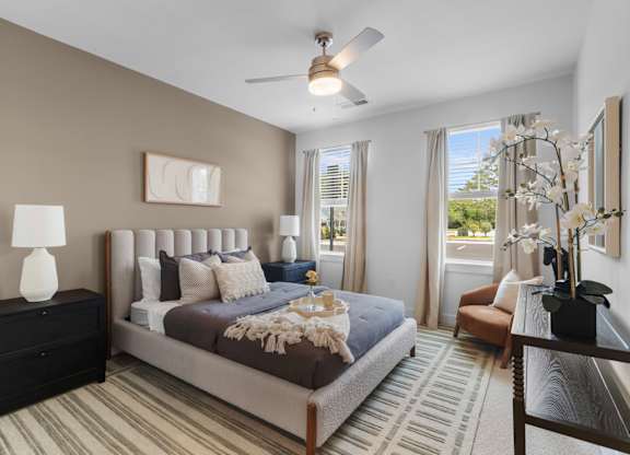 A bedroom with a large bed and a ceiling fan.