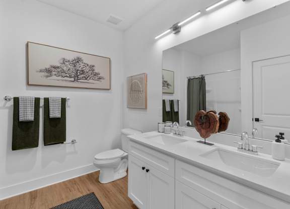 A white bathroom with a toilet, sink, and mirror.