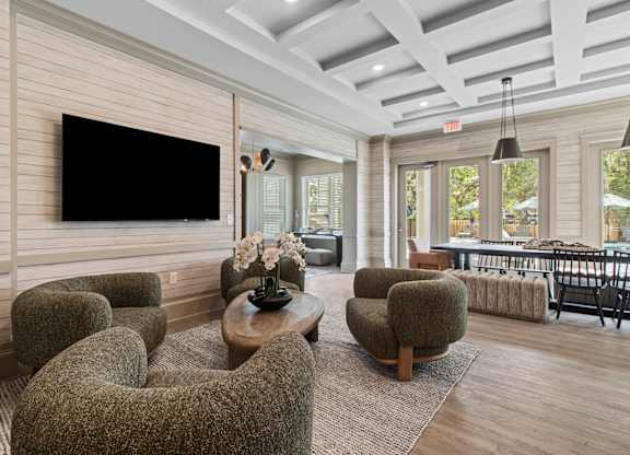 A living room with a flat screen TV mounted on the wall.