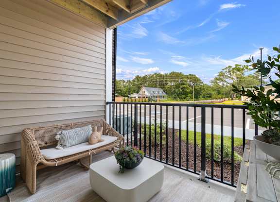 A balcony with a sofa, table and plants.