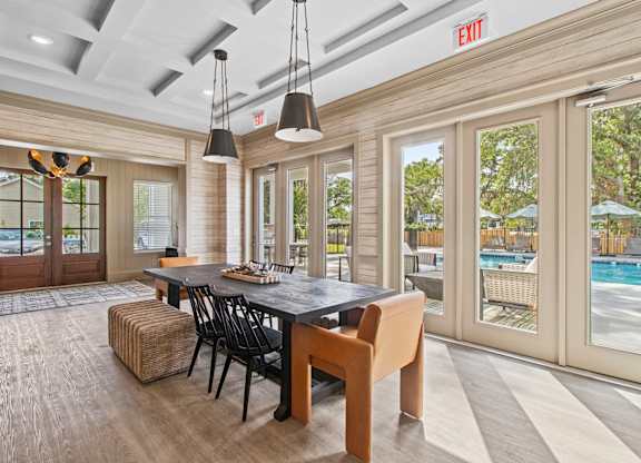 A dining room with a pool in the background.